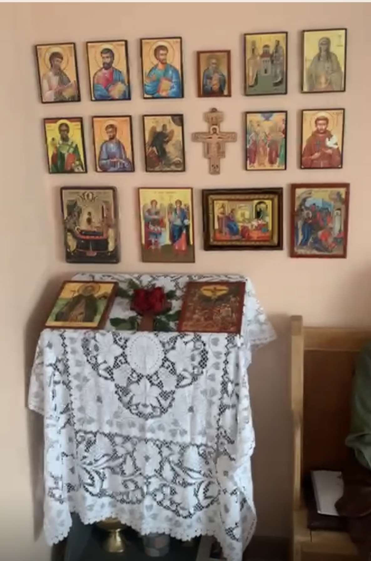 The icon wall with apostles, saints, the San Damiano cross, and feast icons of the Theotokos